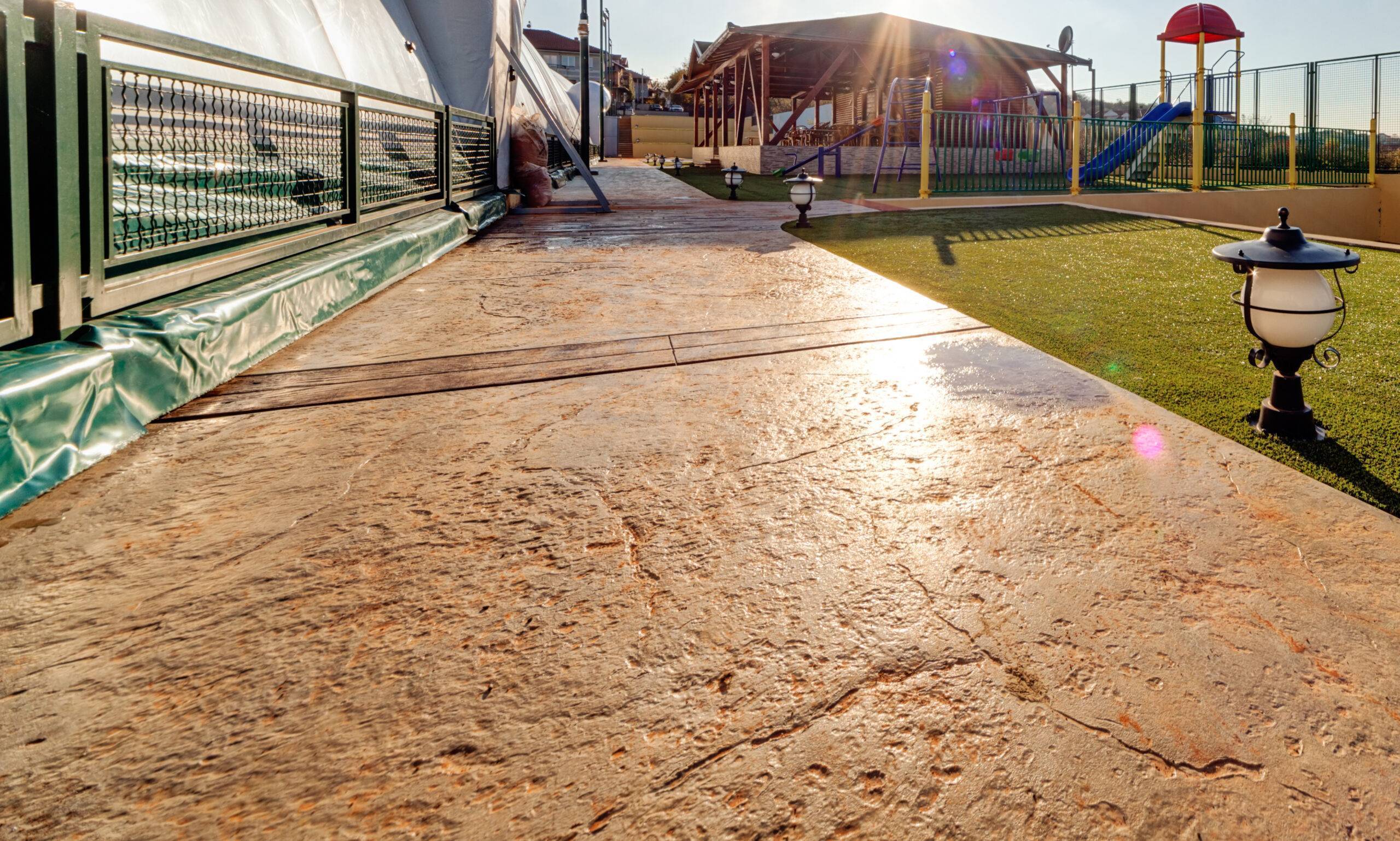 A concrete walkway constructed by a Tulsa Concrete Contractor with a playground in the background.