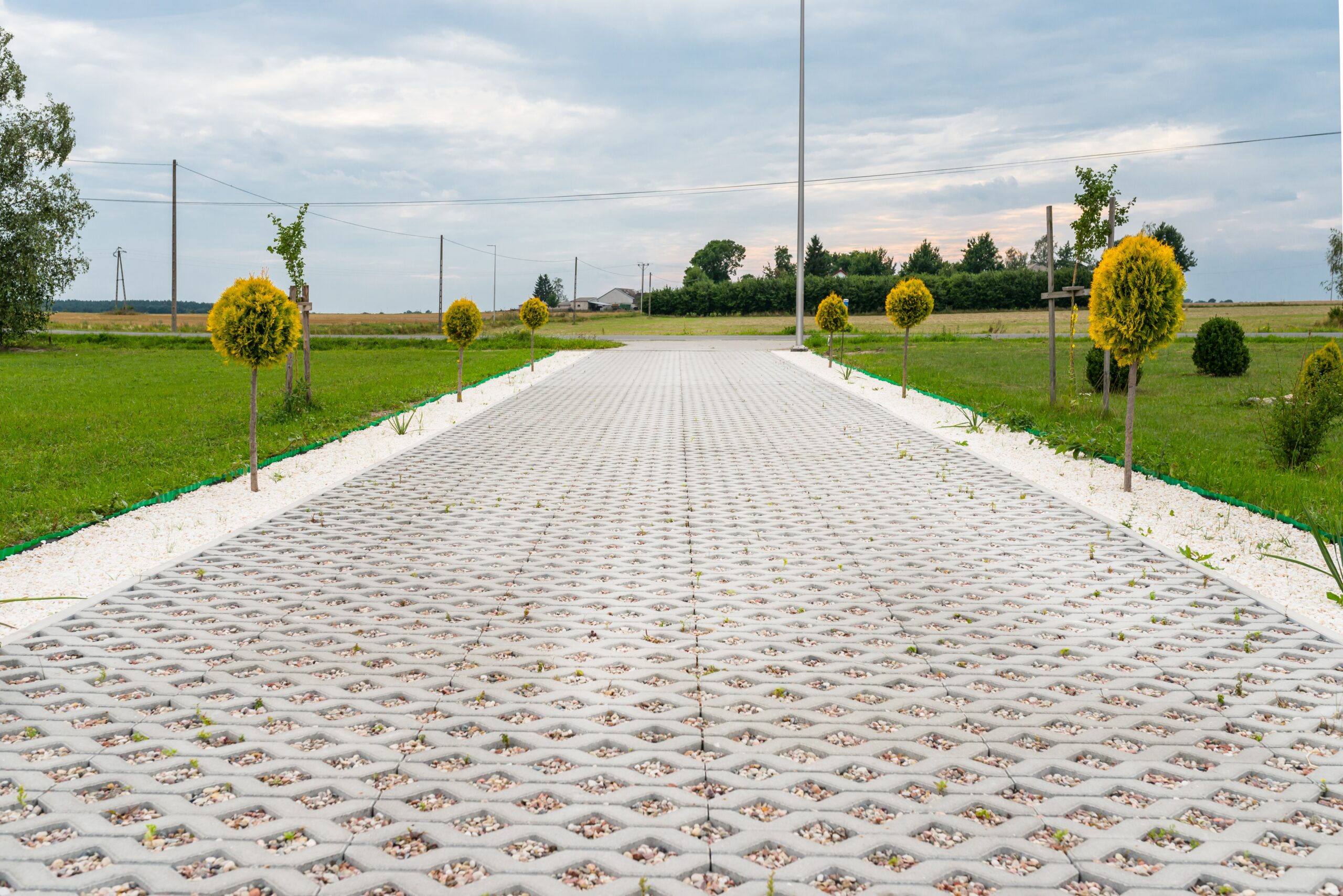 A concrete walkway in the middle of a grassy field.